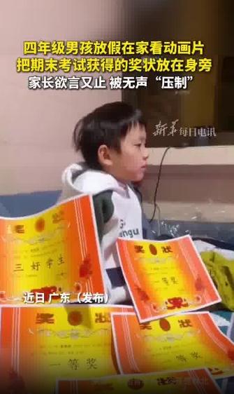 男孩摆奖状看电视 爸爸欲言又止
