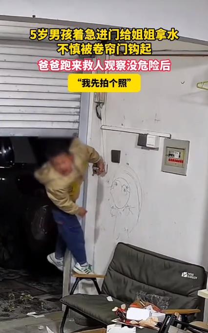 娃被卡到半空 爸爸先掏手机拍照